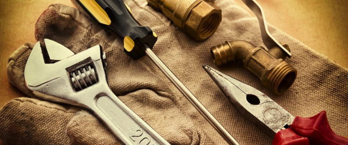 a pair of gloves with tools on it used by HVAC, Plumbers and Electricians in the Trades