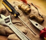 a pair of gloves with tools on it used by HVAC, Plumbers and Electricians in the Trades