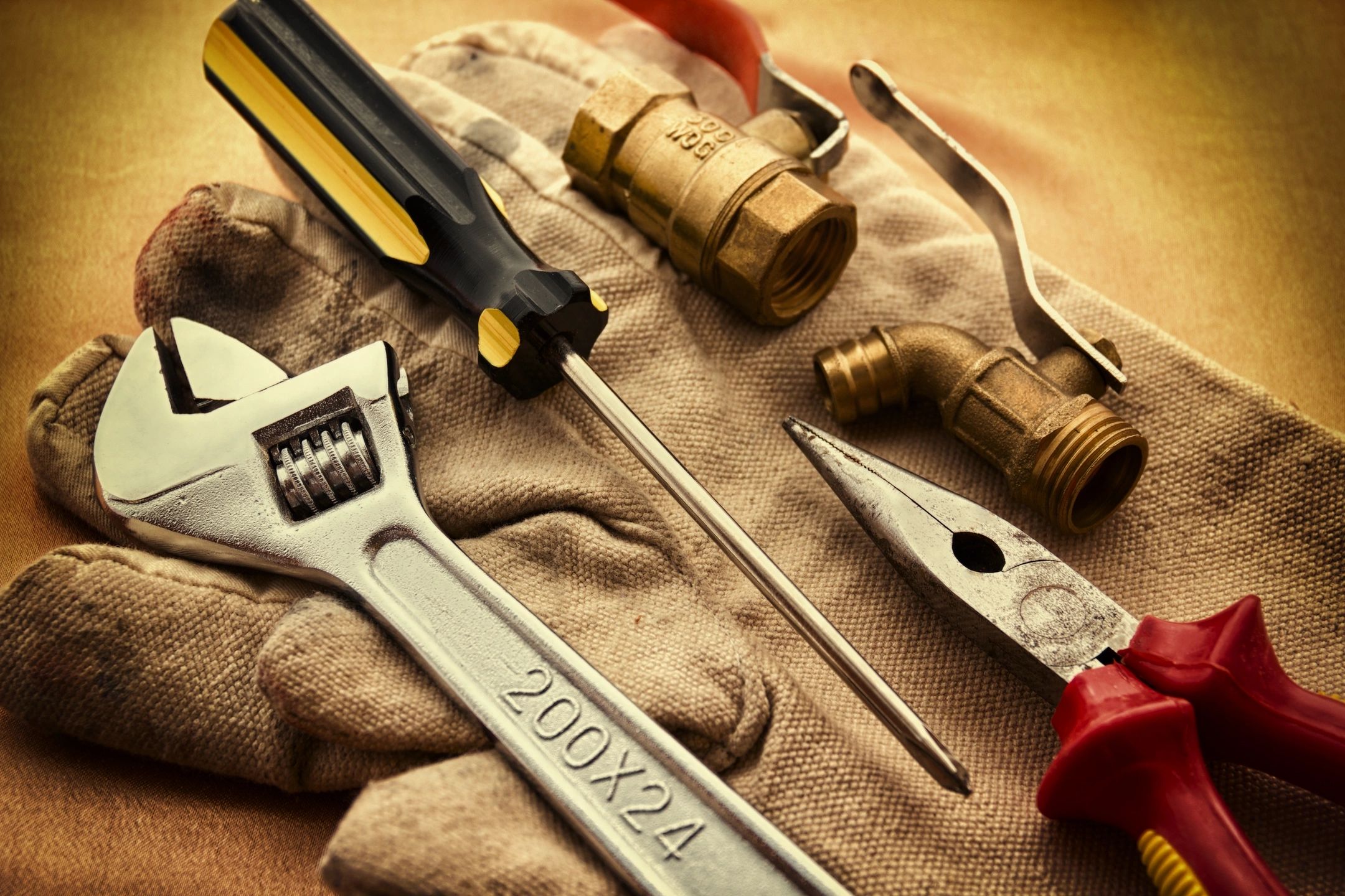 a pair of gloves with tools on it used by HVAC, Plumbers and Electricians in the Trades